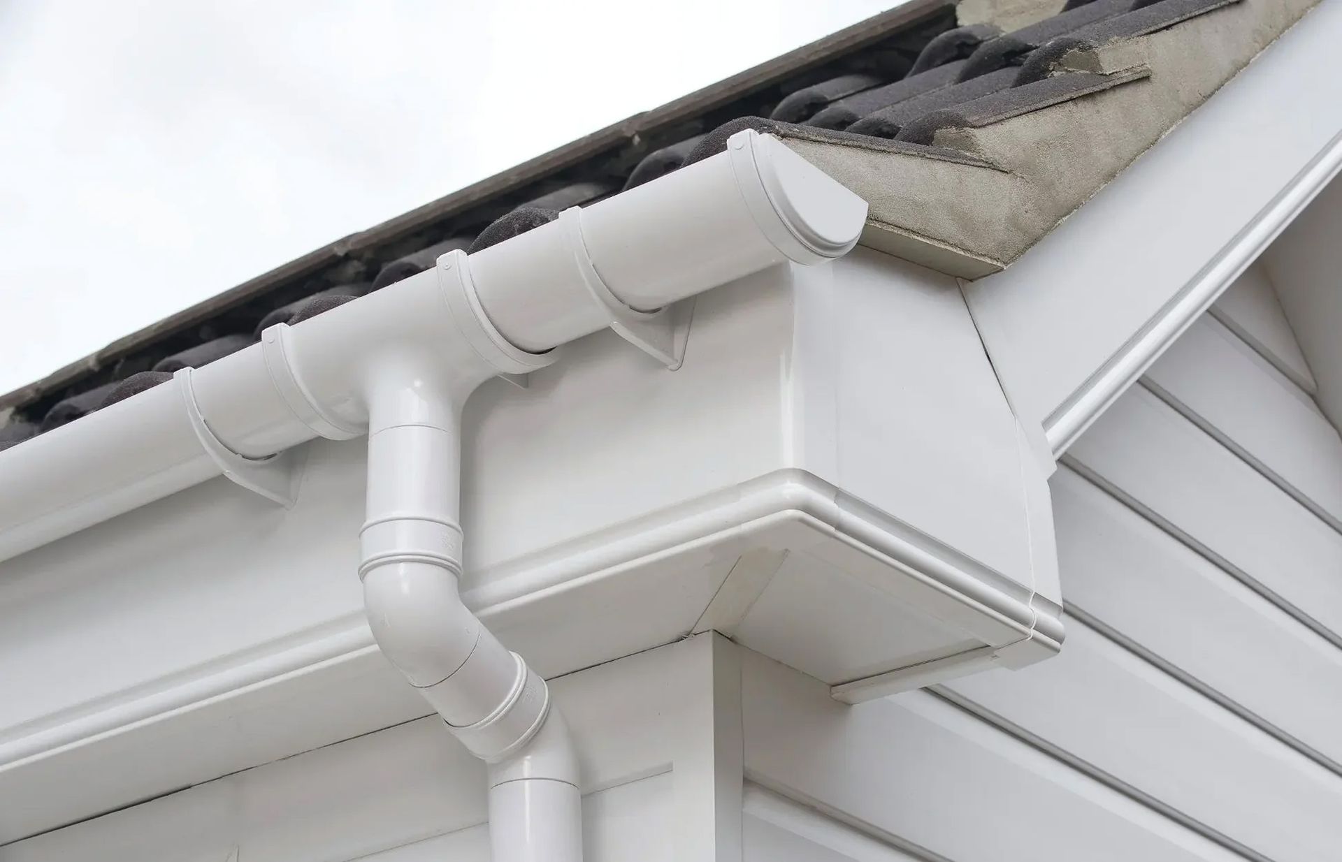 a close up of a white gutter on the side of a house