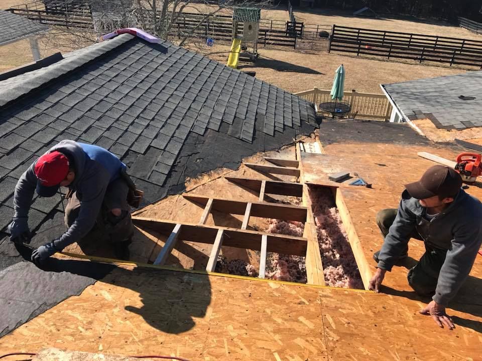 two men are working on the roof of a house