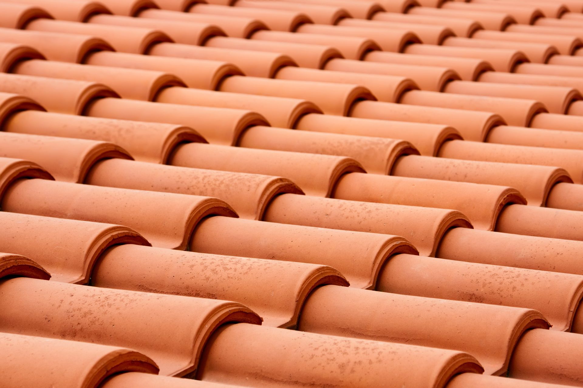 a close up of a row of red tiles on a roof