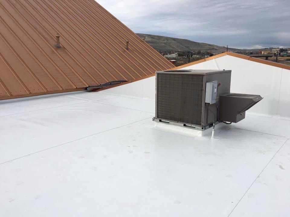 two men are working on the roof of a house