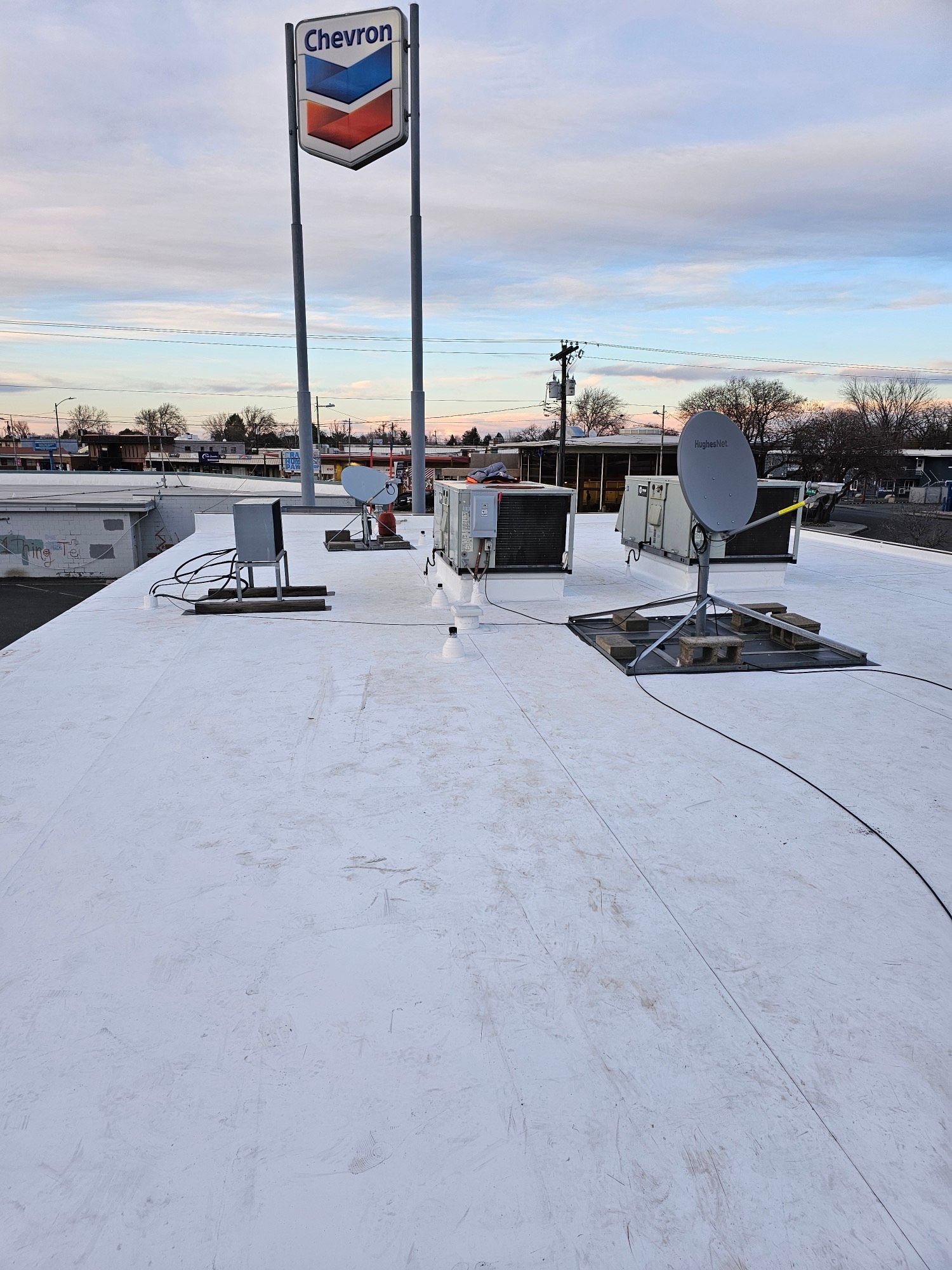 two men are working on the roof of a brick house
