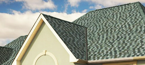 a house with a green roof and a blue sky in the background
