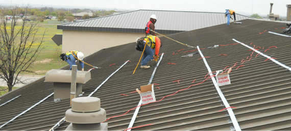 a group of men are working on the roof of a building