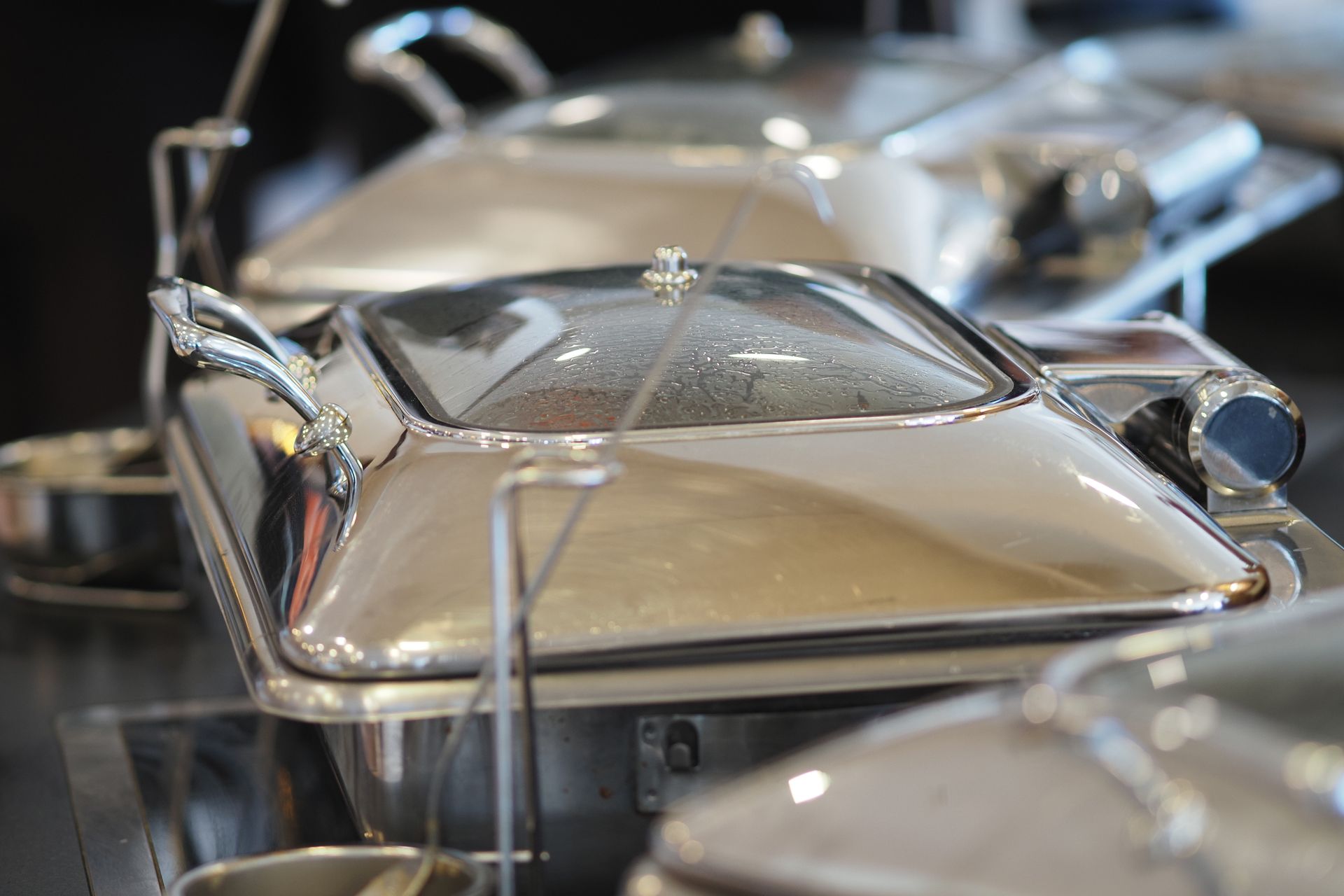Warm food trays at a buffet in a restaurant setting.