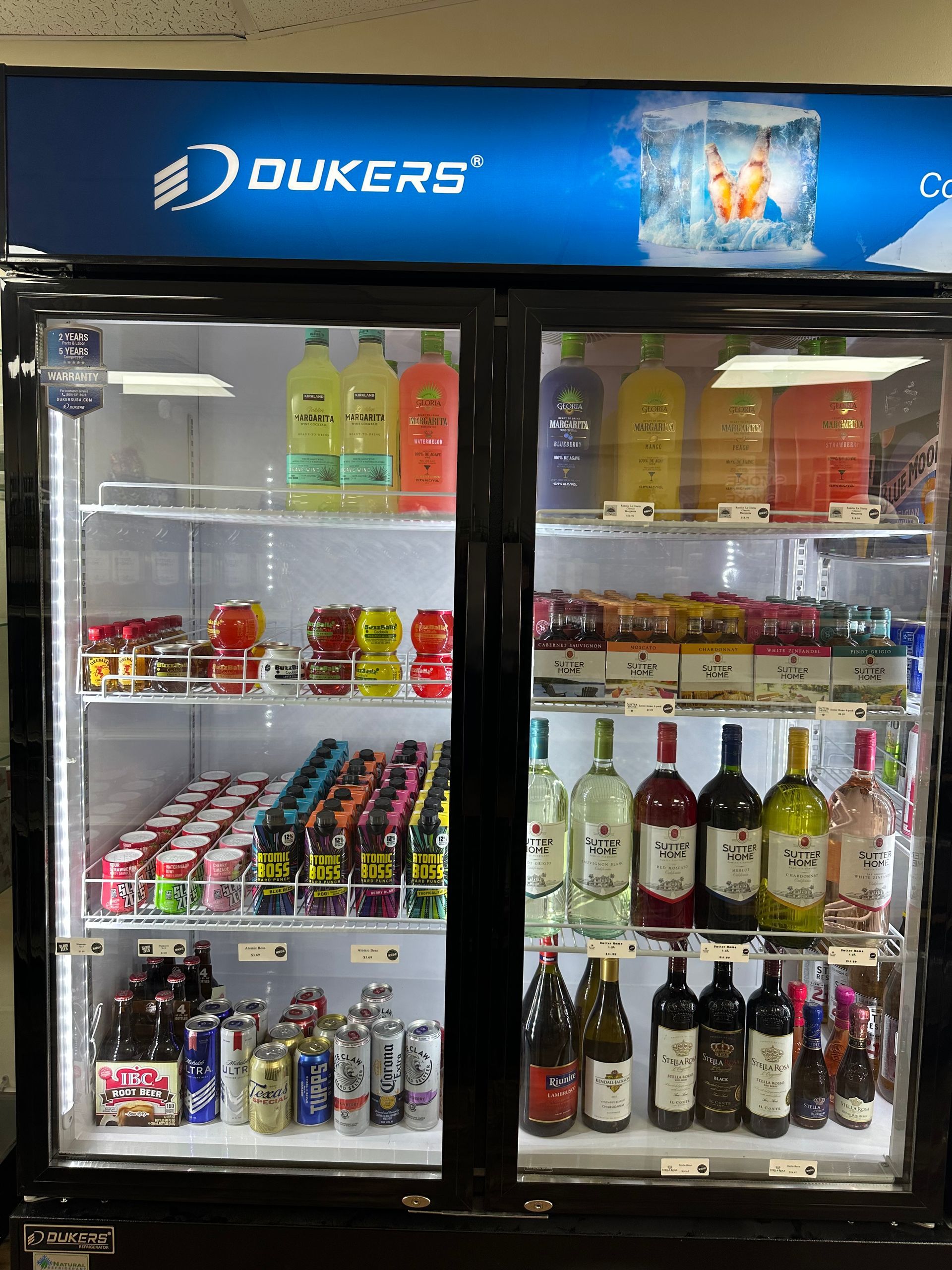 A refrigerated display case stocked with various beverages and alcohol at a store.