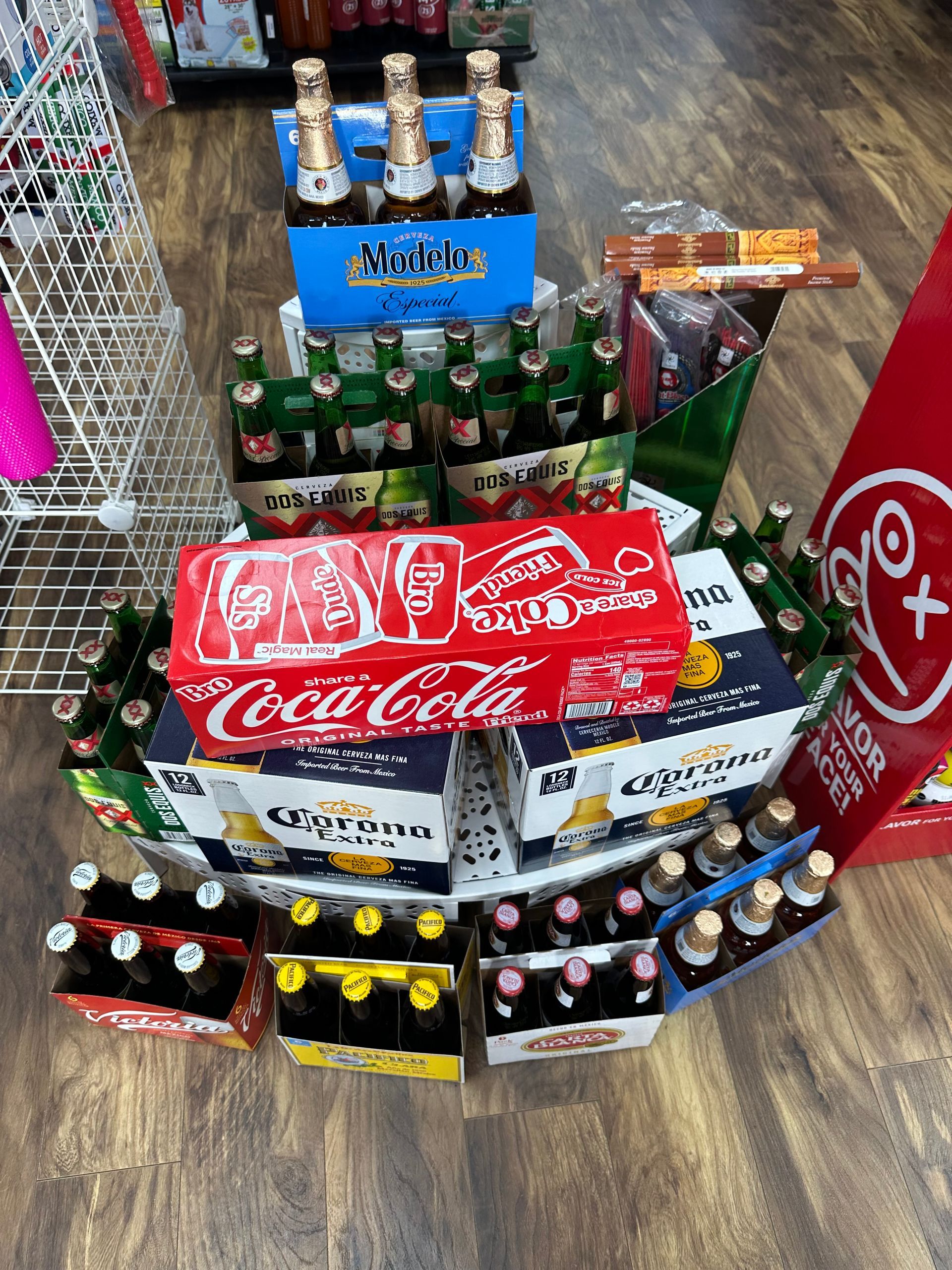 Display of assorted beverages: champagne, beer, soda, and other drinks in a store setting.