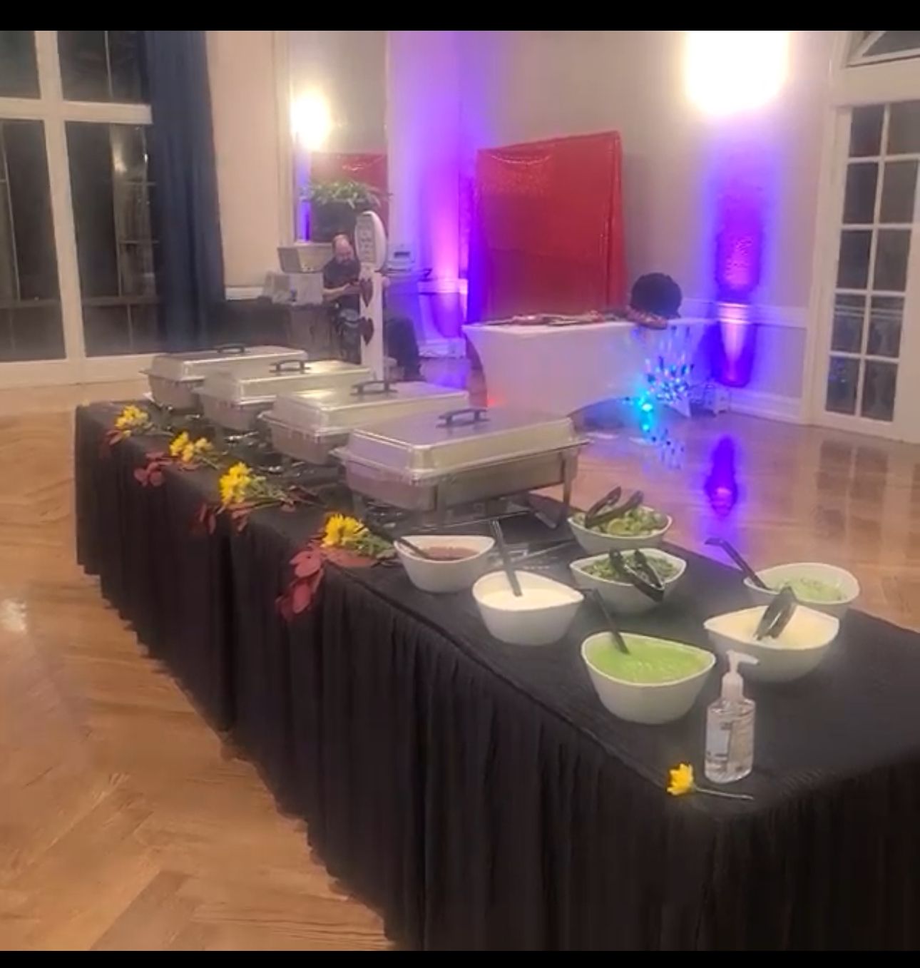 A long table with bowls of food on it in a room.