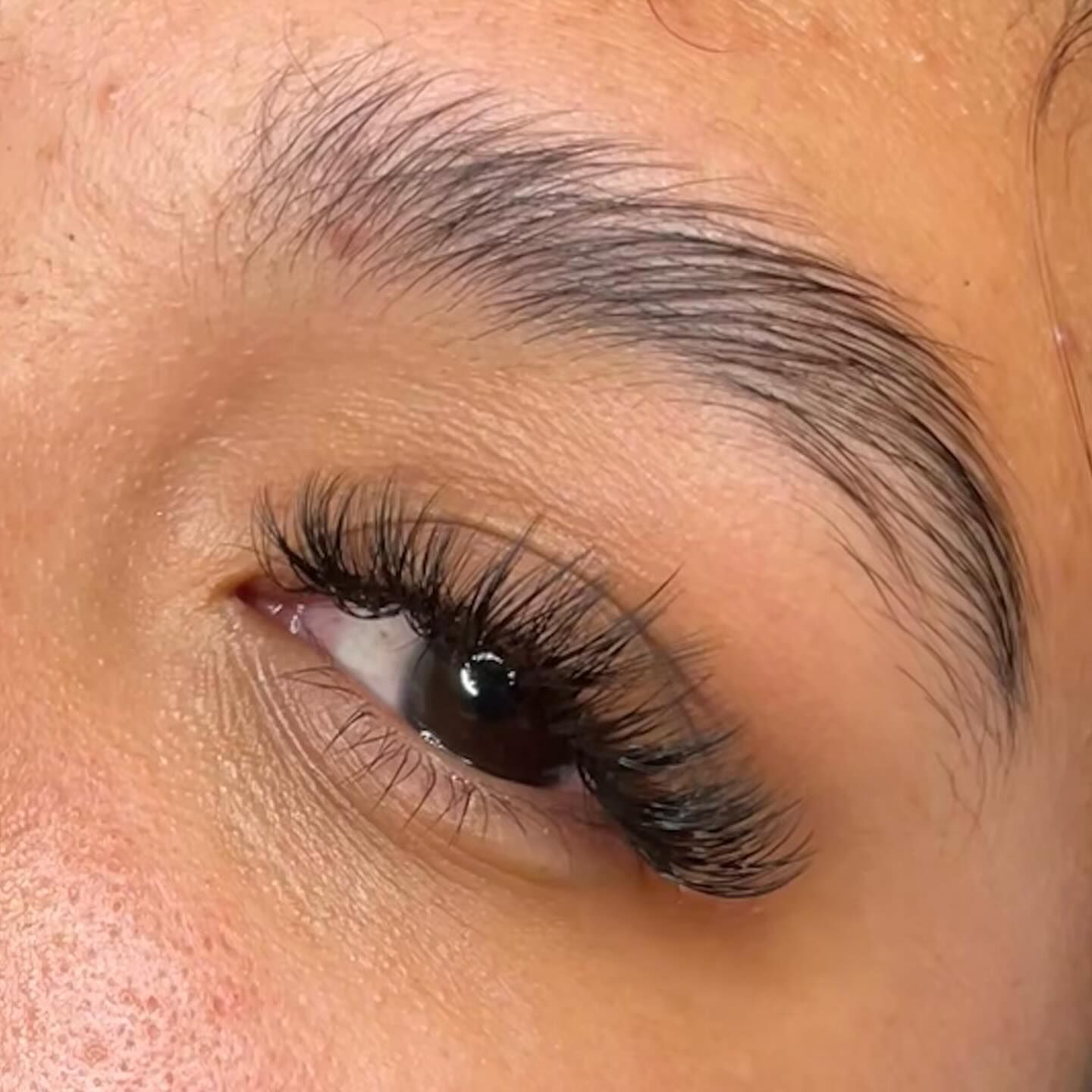 A woman is applying mascara to her eyelashes.