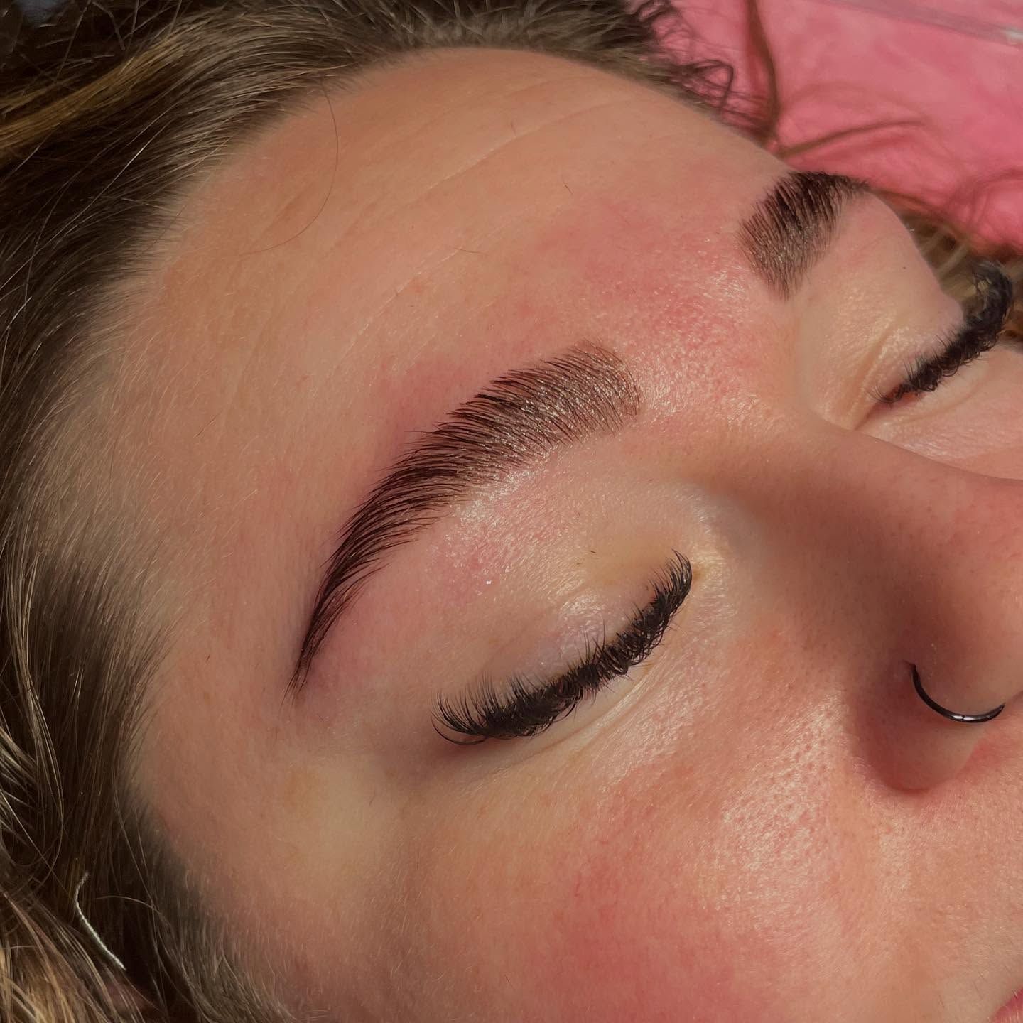 A woman is applying mascara to her eyelashes.