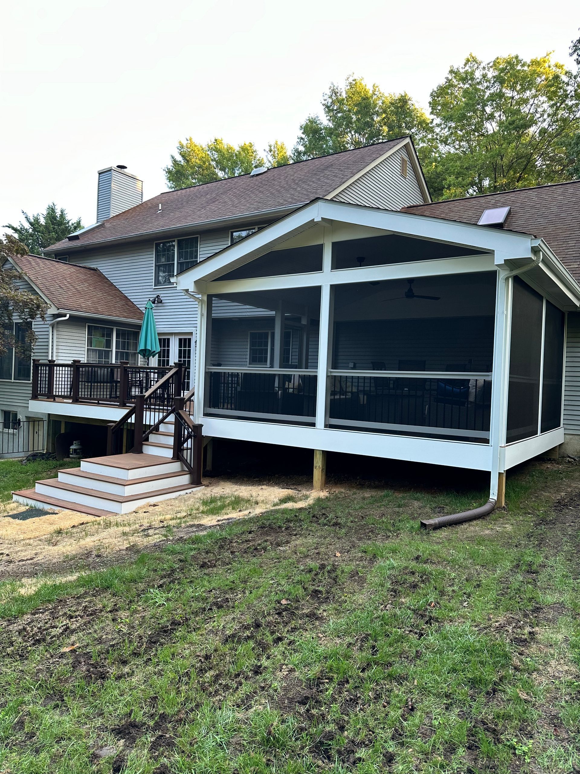 A house with a screened in porch and a deck.