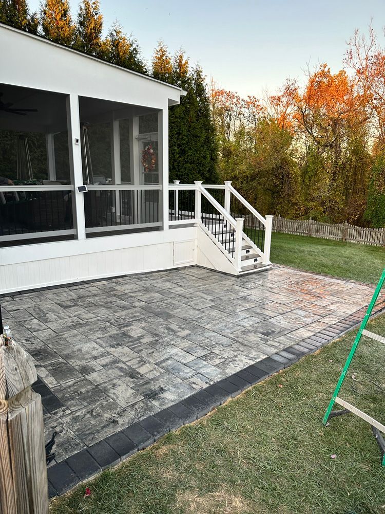 A white house with a screened in porch and stairs.