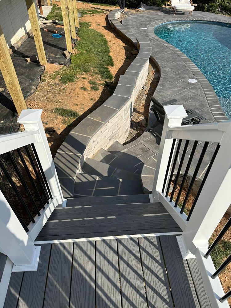 A deck with stairs leading up to a swimming pool.