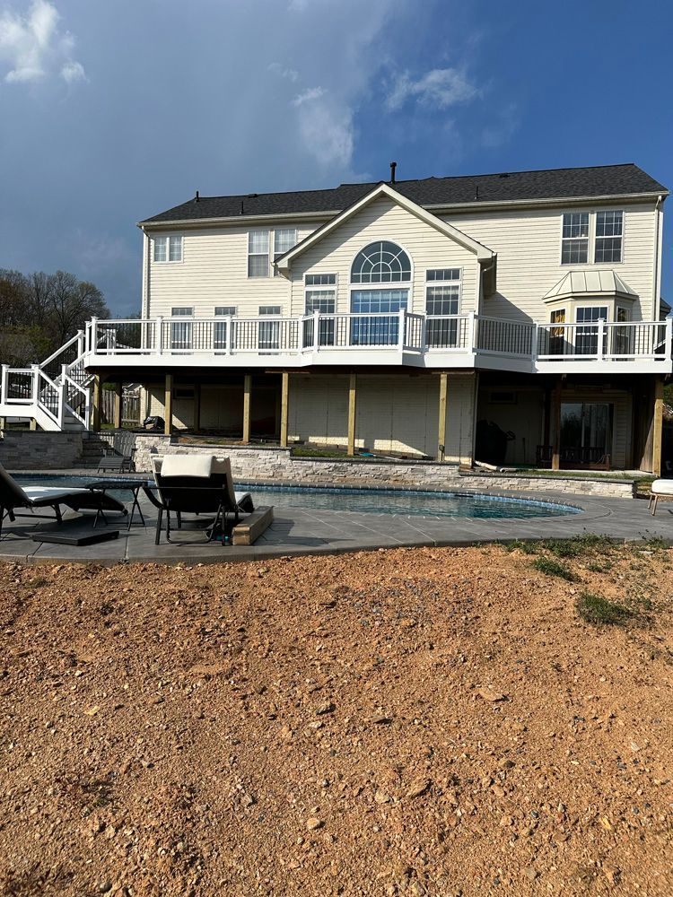 A large white house with a swimming pool in front of it.