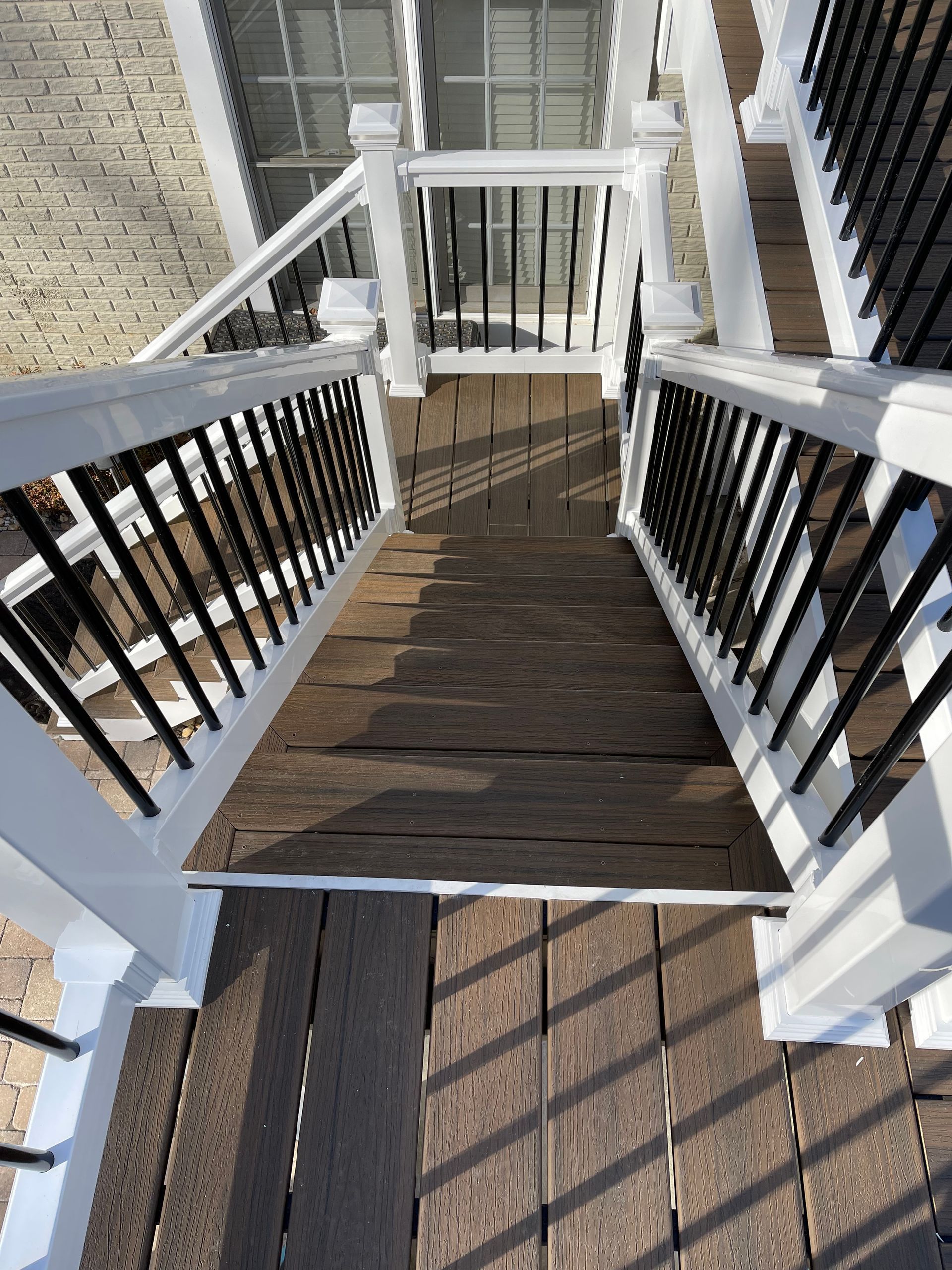 A wooden deck with stairs and a white railing