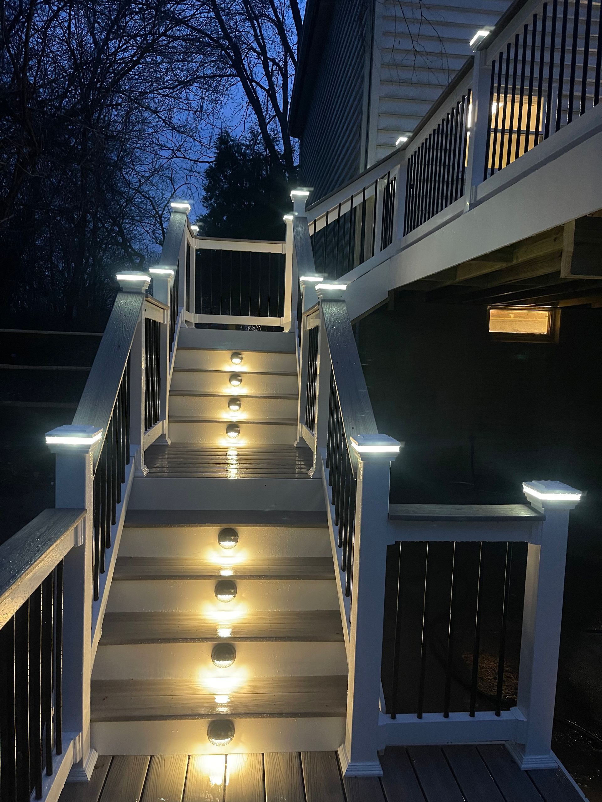 A deck with stairs that are lit up at night