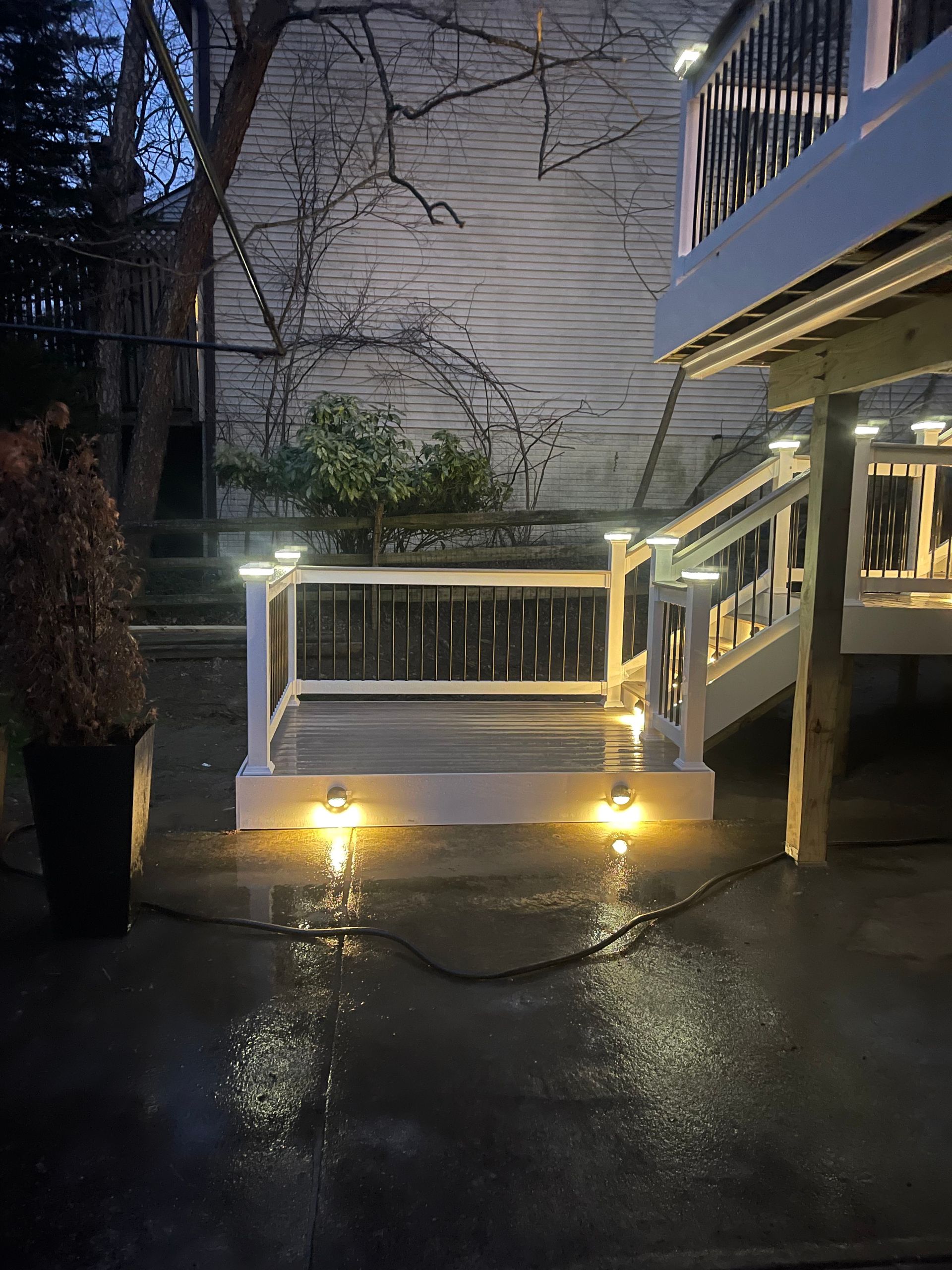 A person is standing next to a deck with lights on it at night.