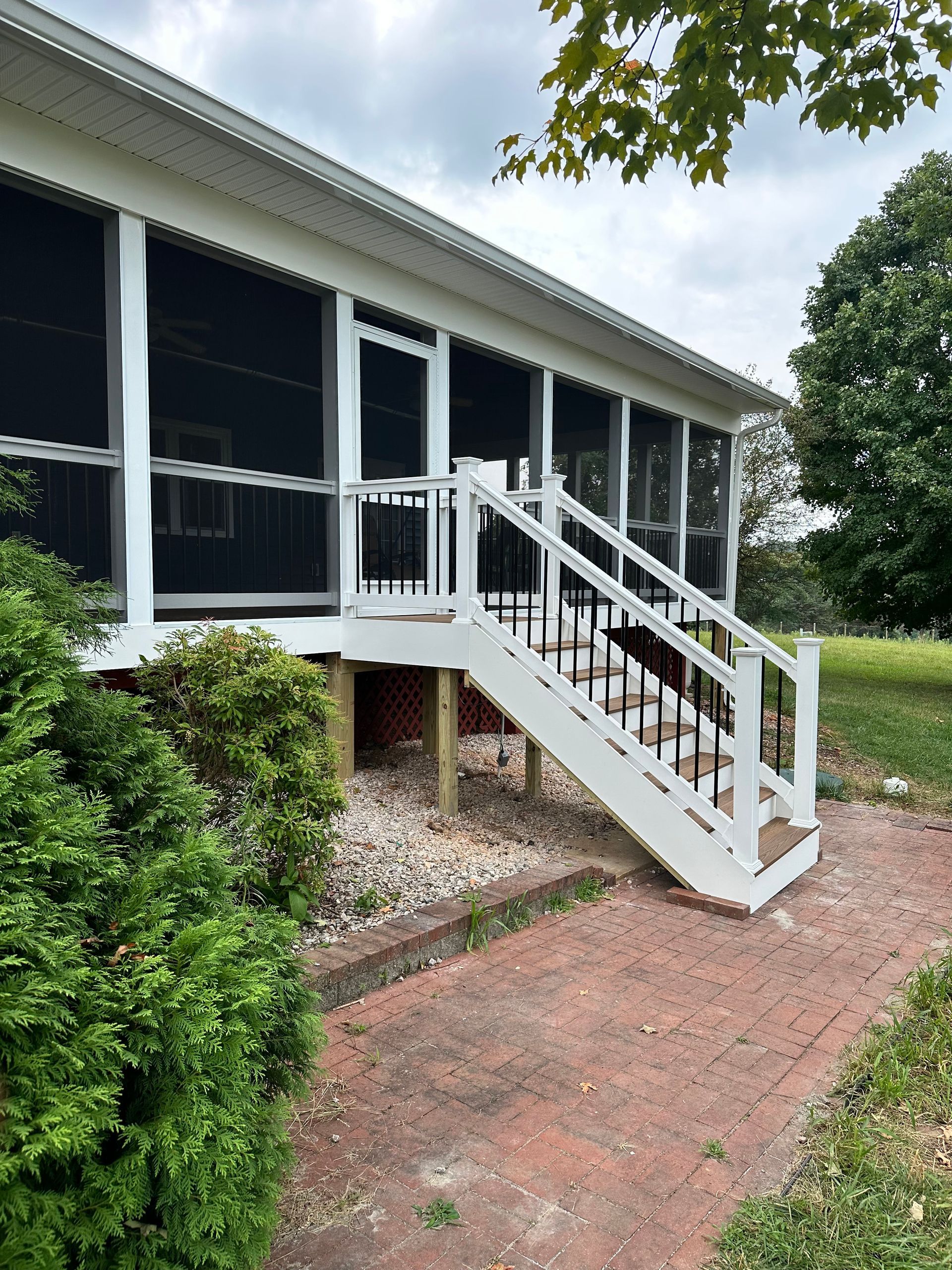 A screened in porch with stairs leading up to it.