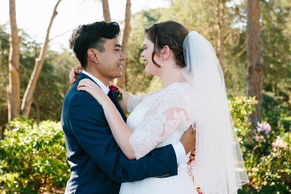 A bride and groom are hugging and looking at each other.