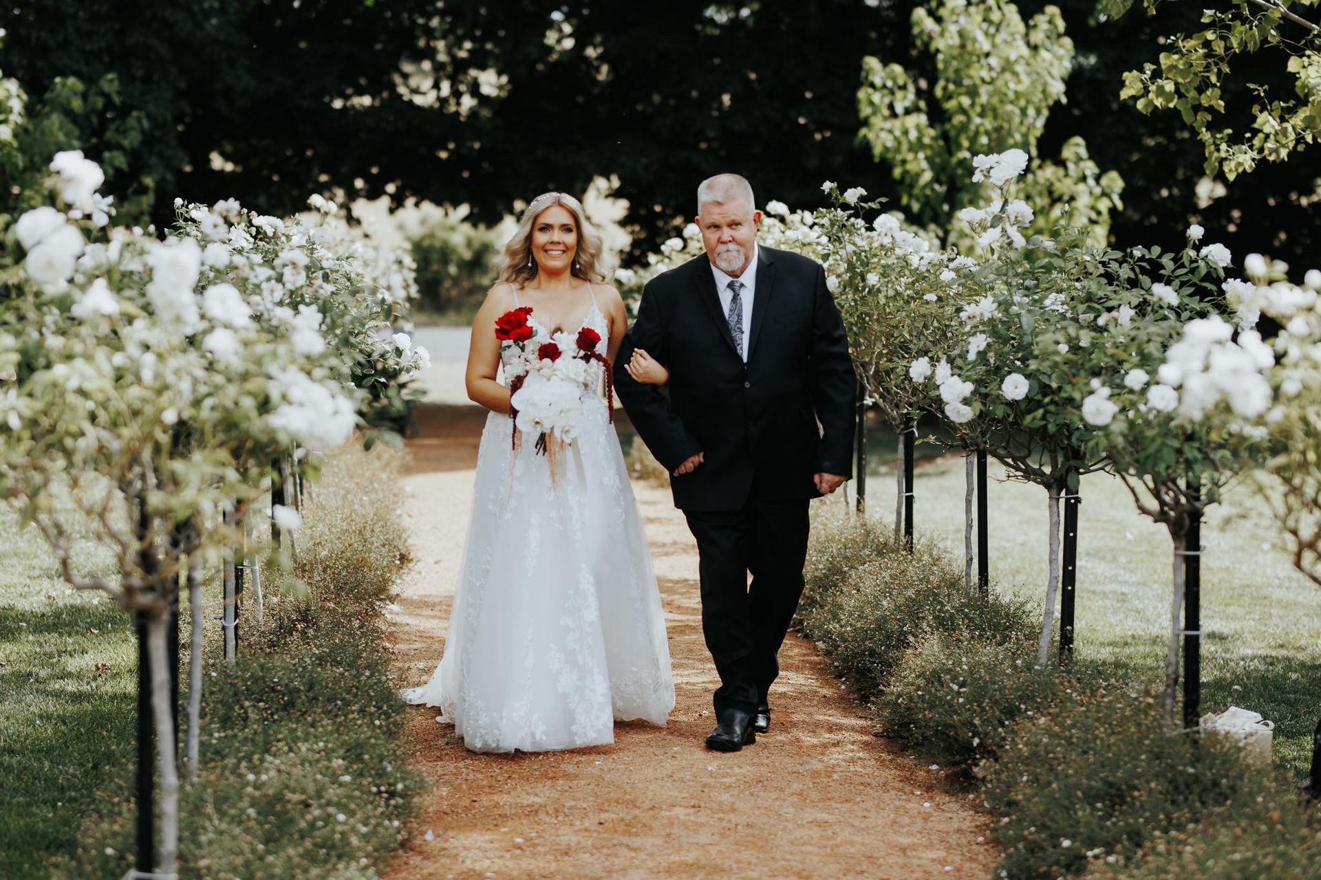 A bride and her father are walking down the aisle at the wedding.