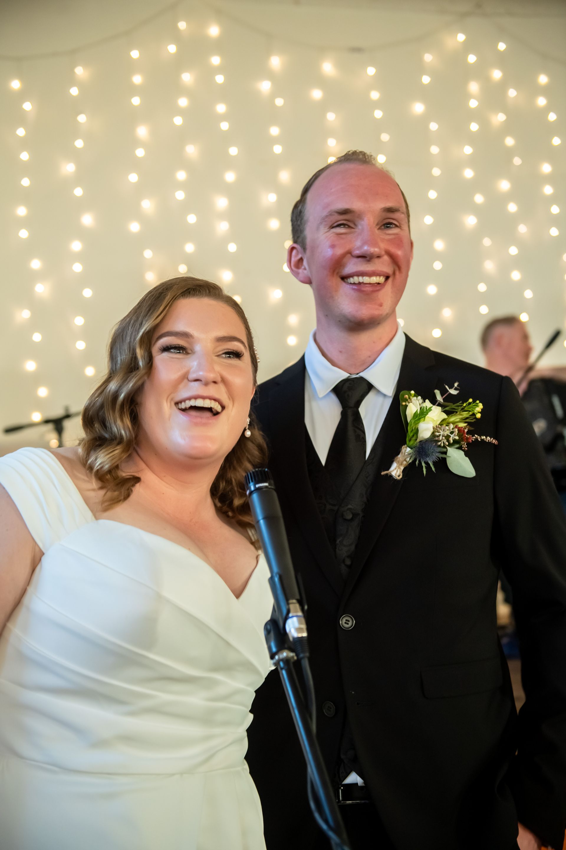 A bride and groom are posing for a picture at their wedding reception.