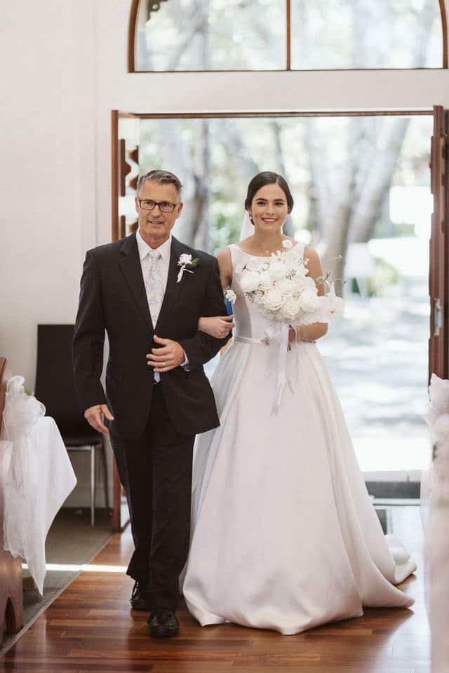 A bride and her father are walking the aisle