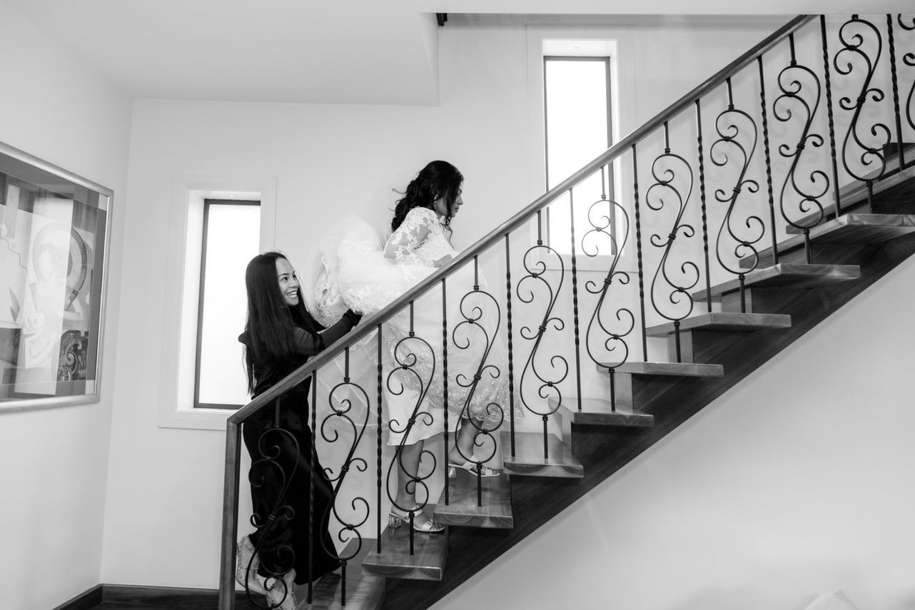 A black and white photo of two women walking up a set of stairs.