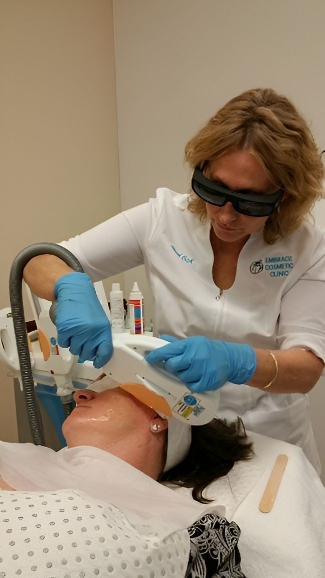 A Person Receiving a Facial Laser Treatment From a Professional — Embrace Cosmetic Clinic in Bundaberg North, QLD