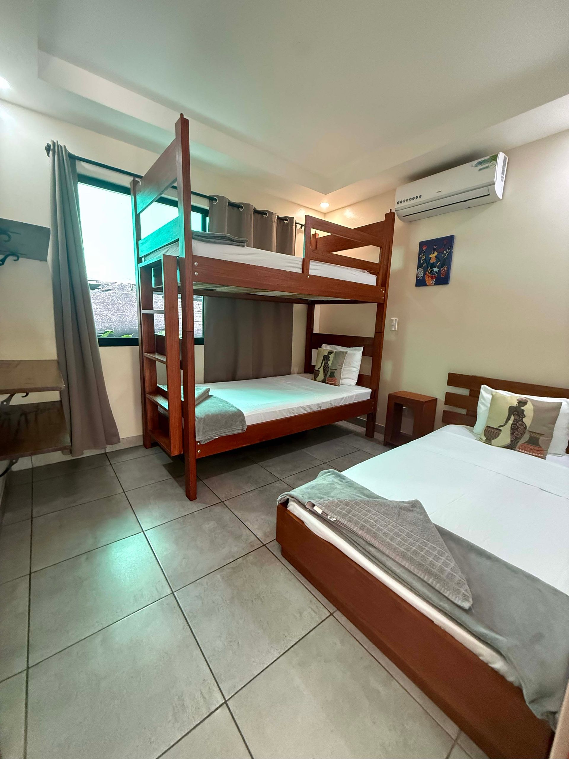 Bedroom with bunk beds, a single bed, and an air conditioner.