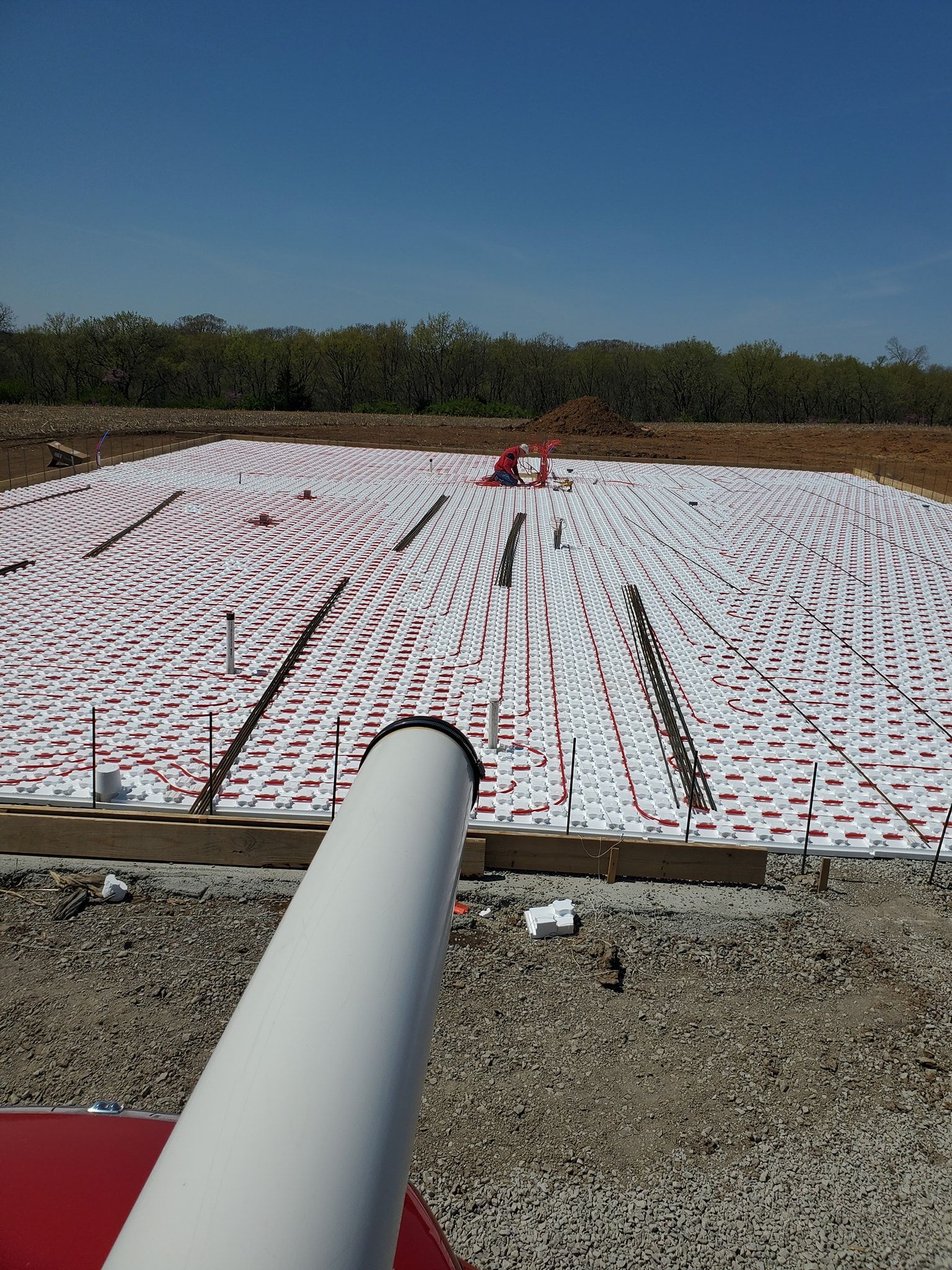 A white pipe is sitting in the middle of a dirt field.
