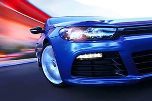 Blue sports car in motion turning left blurred background