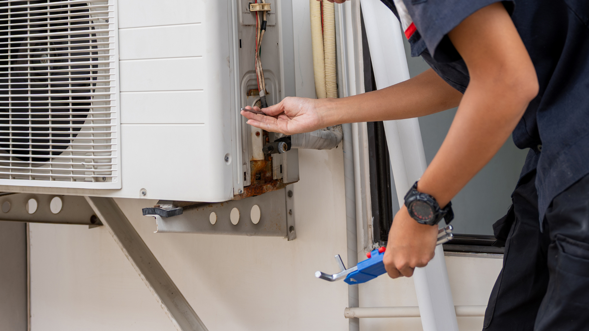 Technician repairs an outdoor AC unit.