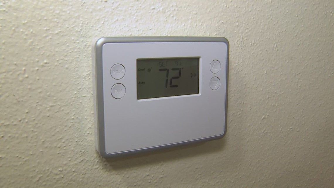 Thermostat displaying 72 degrees, mounted on a beige wall.