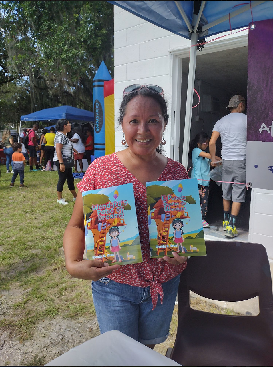A woman is holding two children 's books in her hands