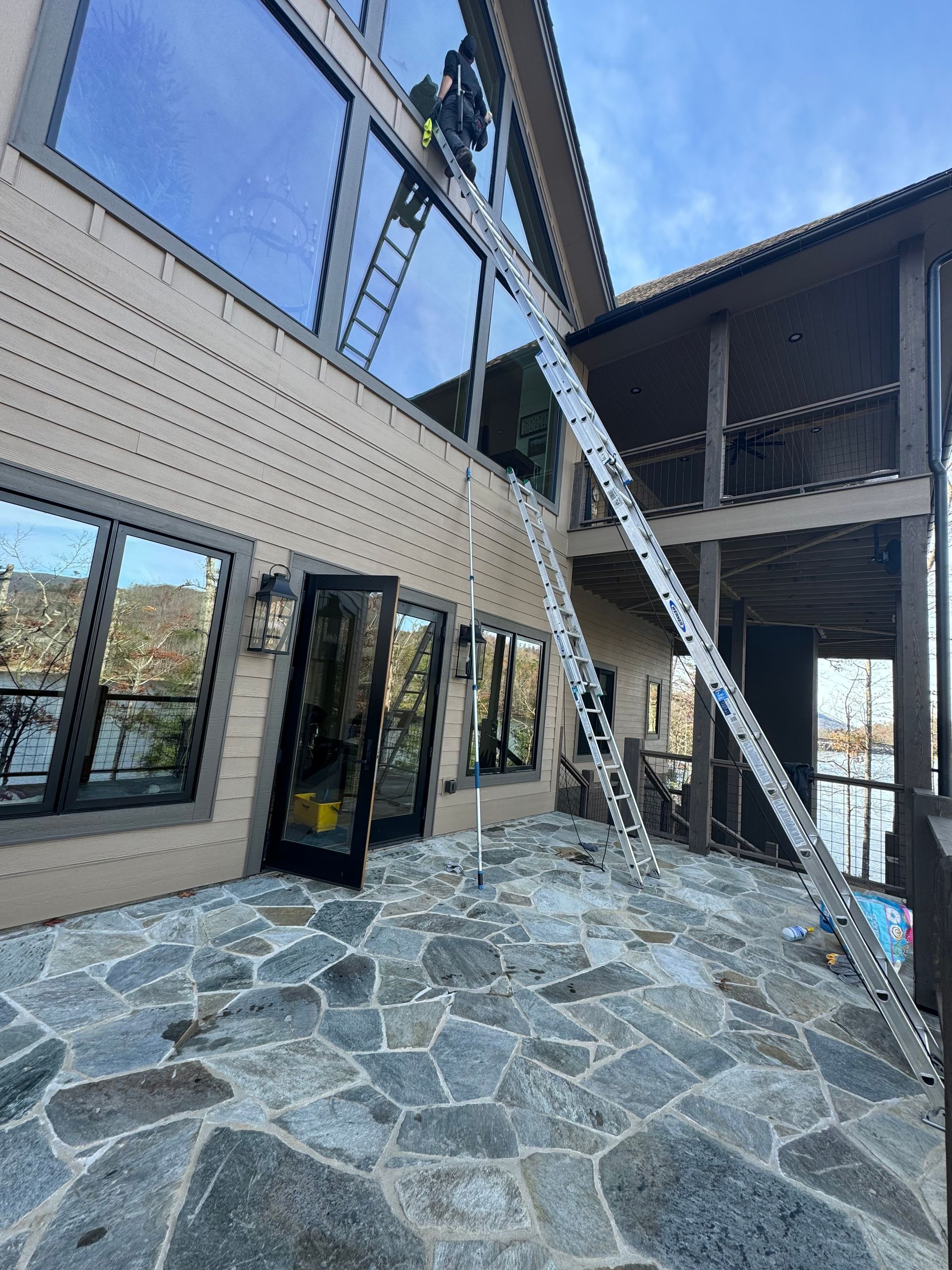 A large house with a ladder hanging from the side of it.
