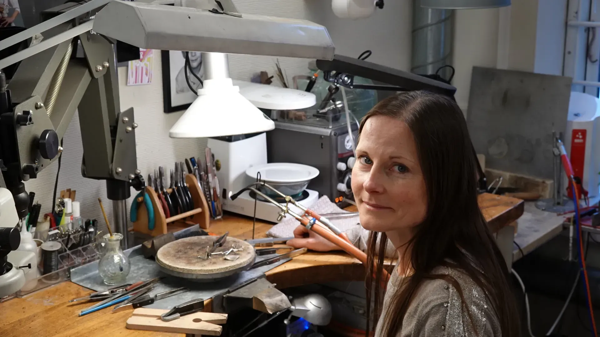 Briller udstillet; blå og lilla stel på en hvid overflade med en dekorativ vase og grønt.