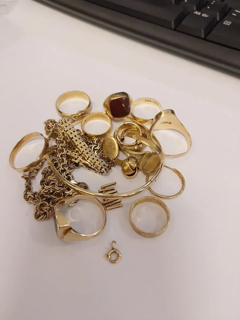 Træbakke med flere herrearmbånd på grå fløjlspuder, der fremviser forskellige stilarter.