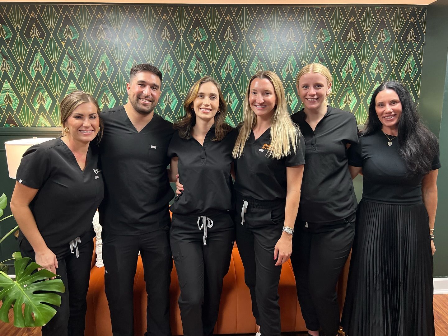 A woman in a green tank top is holding a heart shaped leaf