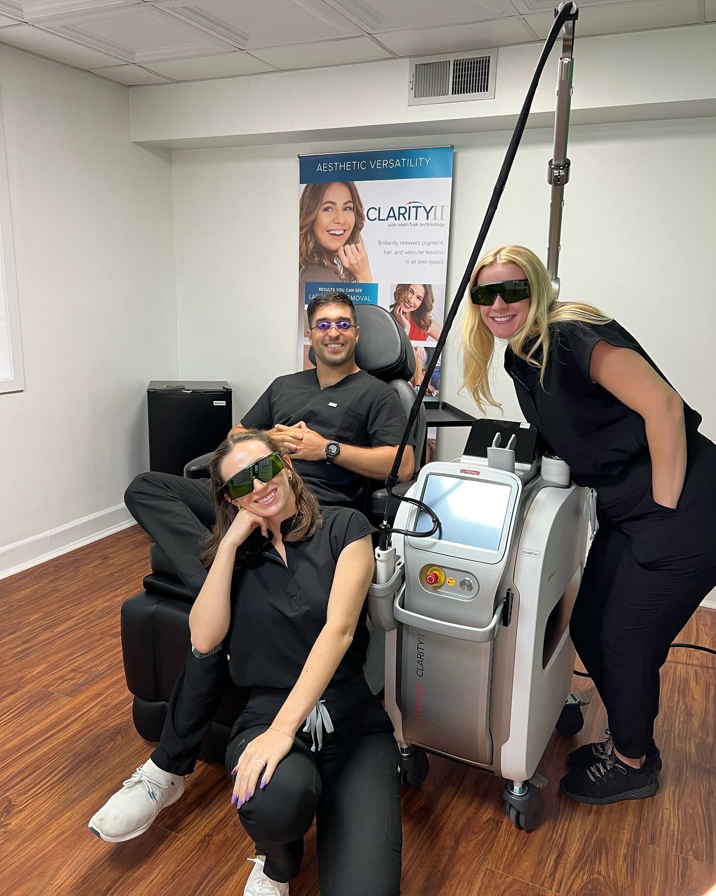 A man and two women are standing next to a machine in a room.