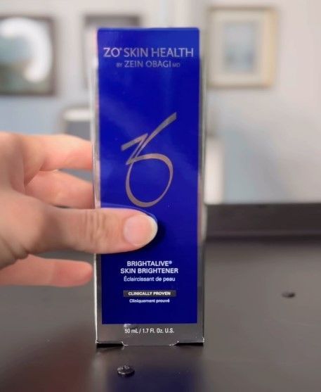 A person is holding a box of zo skin health