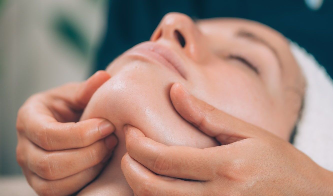 A woman is getting a facial treatment at a beauty salon.