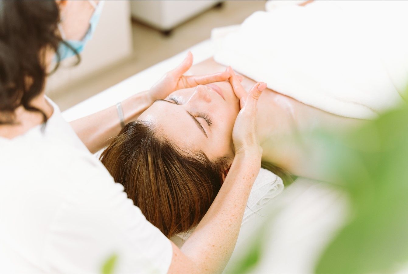 A woman is getting a facial treatment at a beauty salon.