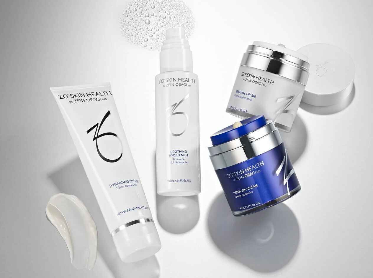 A group of cosmetics including a lotion and a cream are sitting on a table.
