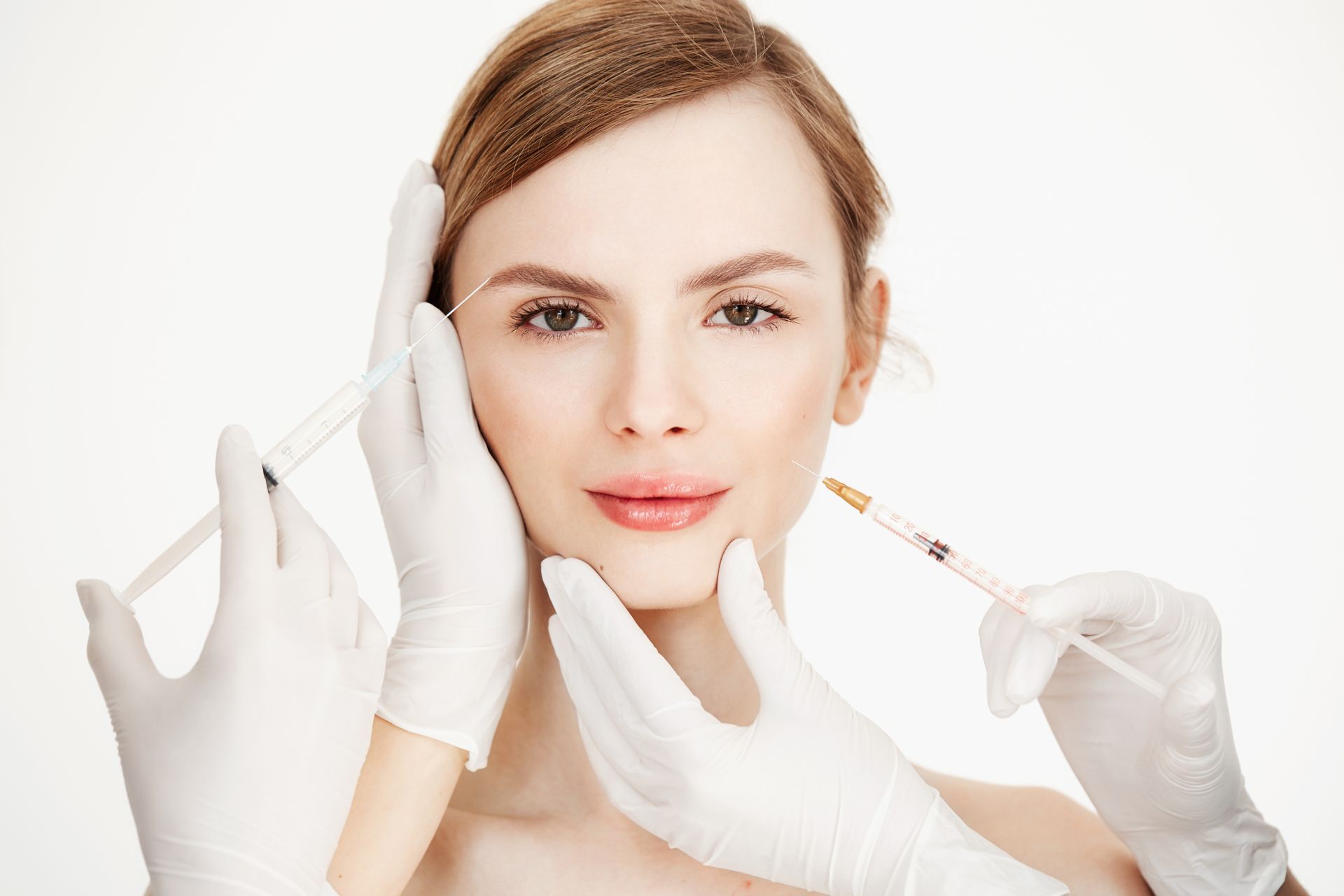 A woman is getting a botox injection in her face.