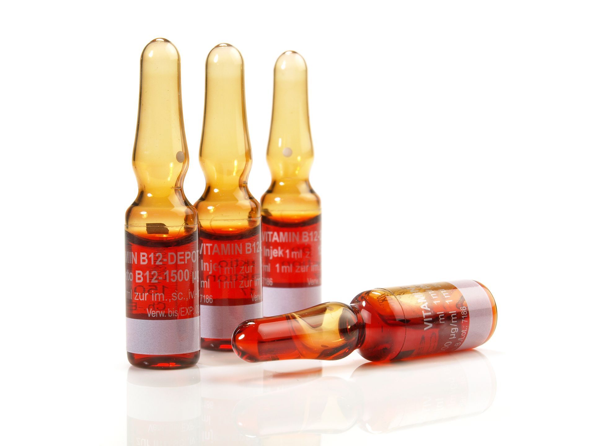 Four bottles of injections are sitting on a white surface.