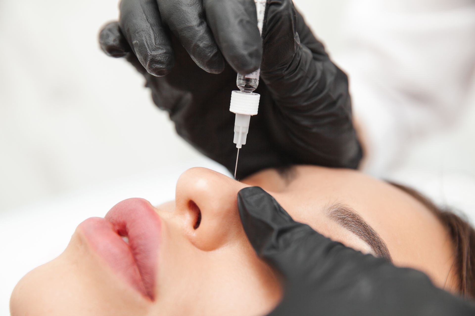 A woman is getting an injection in her nose.