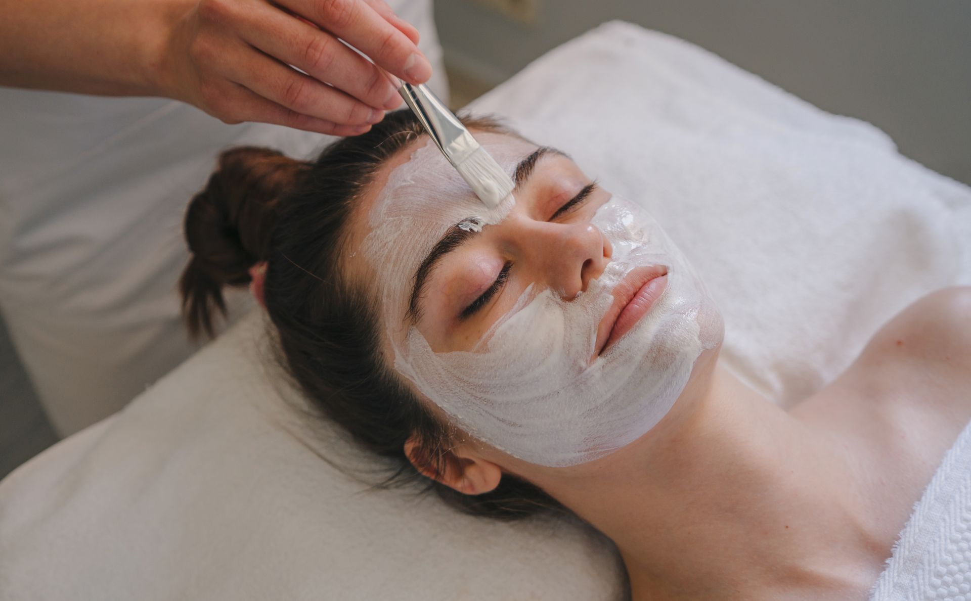 A woman is getting a facial treatment at a spa.