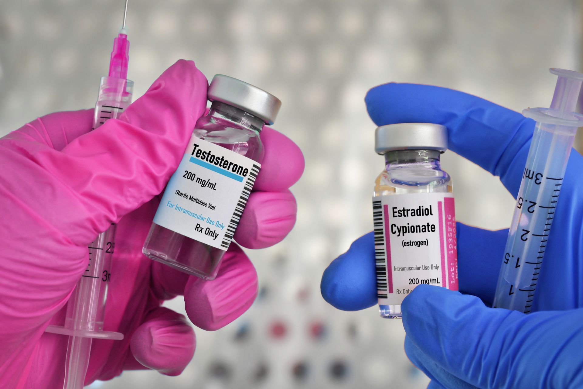 A person wearing pink gloves is holding a syringe and a bottle of vaccine.