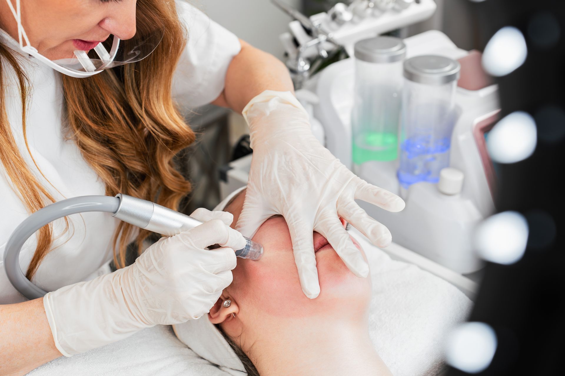 A woman is getting a facial treatment at a beauty salon.