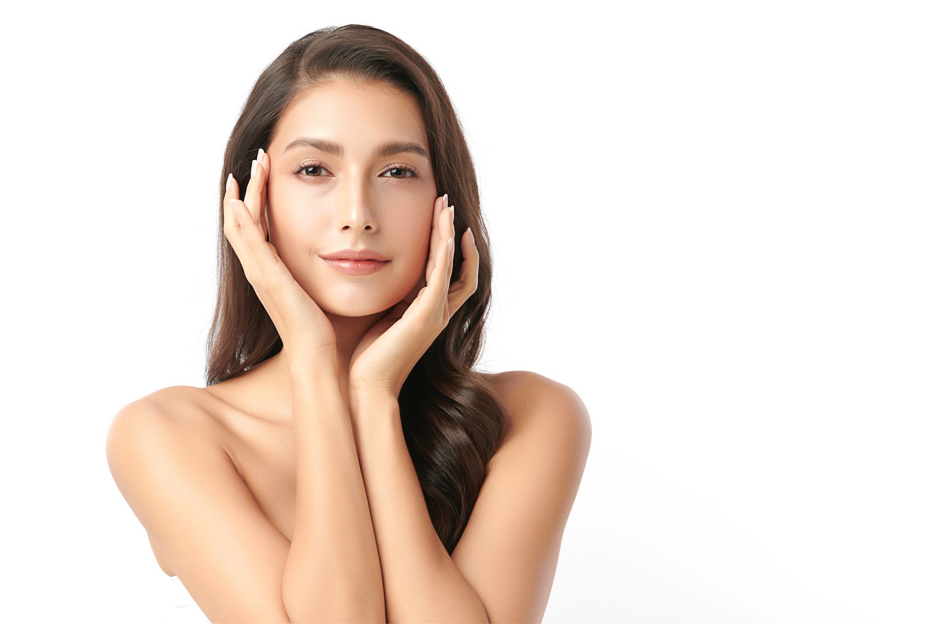 A woman is touching her face with her hands and smiling.