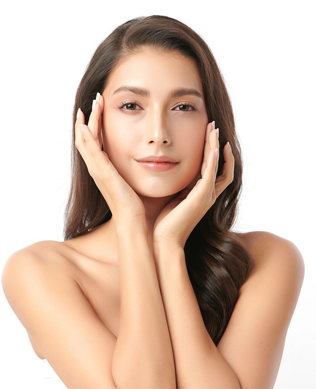 A woman is touching her face with her hands and smiling.